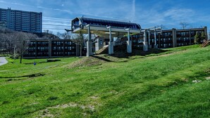 A modern building with a covered outdoor area, surrounded by a grassy landscape and other residential buildings. - Sugar Ski Comfort Unit 225 (Sugar Mountain)