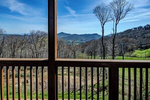 A wooden deck with a view of a mountainous landscape. - Sugar Ski Comfort Unit 225 (Sugar Mountain)