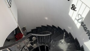 A staircase with a black marble finish, a chandelier, and a sign that reads "Relax & Dream."