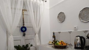 A bathroom with a white sink, a potted plant, a fruit bowl, a bottle of olive oil, and a kettle. - Romantic studio, city center, near beach, next market  and restaurants (Kalymnos)