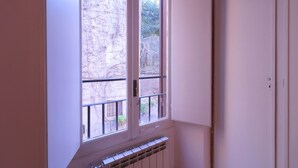 A room with a large window, a radiator, and a door.