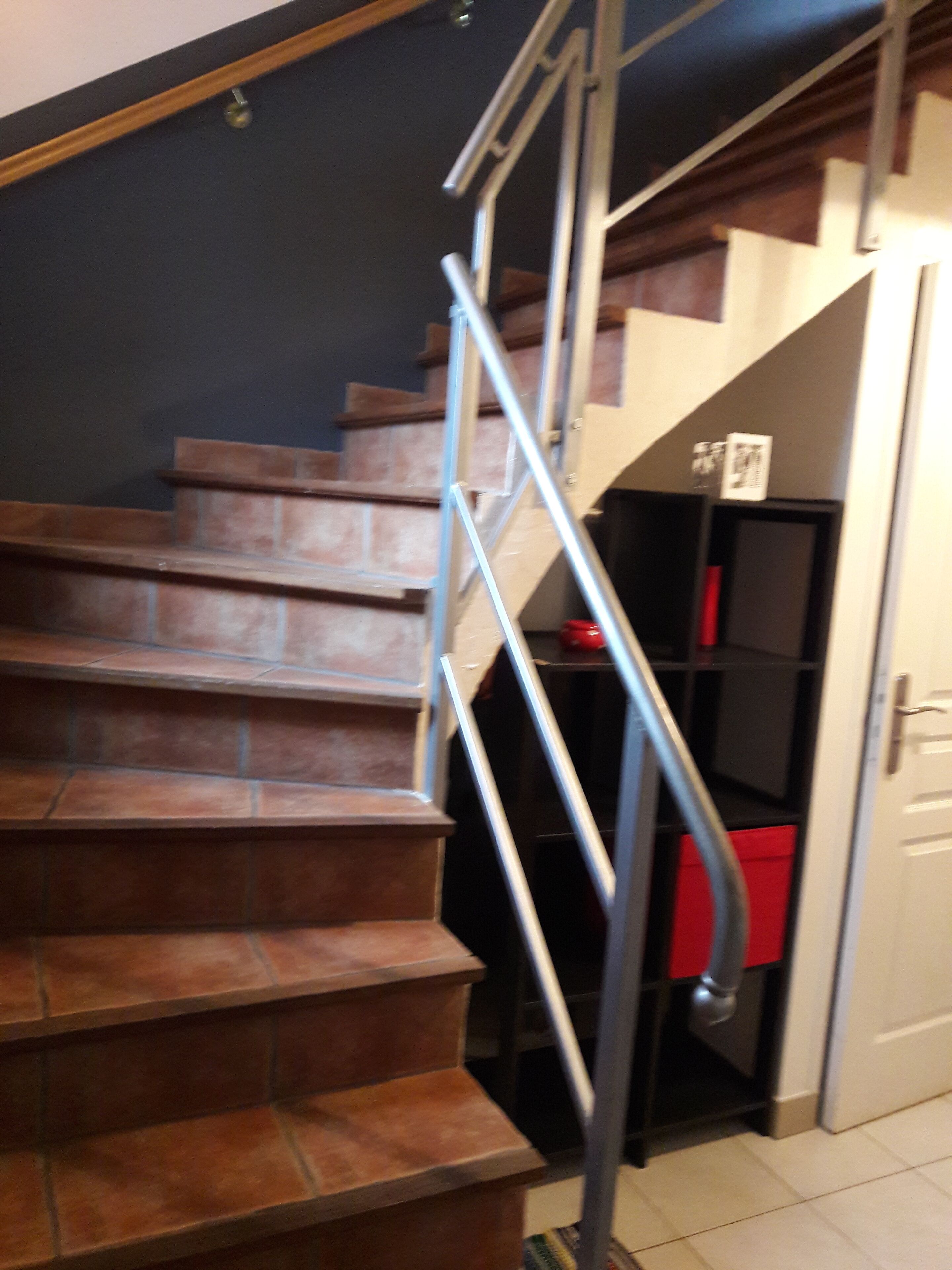 Una escalera con barandillas metálicas que conduce a un rellano.