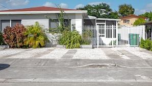 Un quartier résidentiel avec une maison, une clôture blanche et une allée.