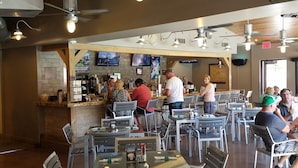 A restaurant with multiple tables and chairs, a bar area, ceiling fans, and televisions on the walls. - Beautiful Las Vegas 2 Bdm Condo In Amazing Resort (Las Vegas)