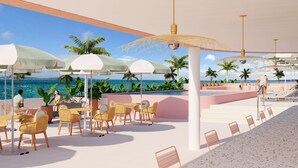 A beachside resort with outdoor seating, palm trees, and a view of the ocean. - Perla La Paz, Tapestry Collection by Hilton (La Paz)