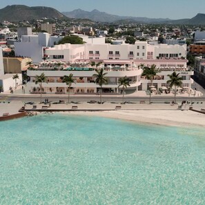 A coastal hotel with a pool, palm trees, and a view of the city and mountains. - Perla La Paz, Tapestry Collection by Hilton (La Paz)