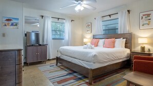 Una habitación de hotel con cama, televisión, escritorio y silla.