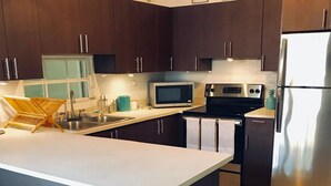 Uma cozinha moderna com armários marrom-escuro, eletrodomésticos de aço inoxidável e uma ilha central.