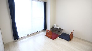A room with a large window, a small table with a kettle, and two bean bag chairs. - Kanazawa-Hub (Kanazawa)