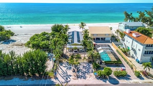 A beachfront property with a swimming pool, a covered patio, and a beach view. - Four Beach Lovers 4 · Full-Size Garden Unit · Solar · Gulf in 50 Steps (Holmes Beach)