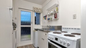 A compact kitchen with a stove, oven, and a window with a view.