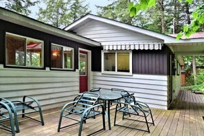 A small cabin with a deck, a dining table, and four chairs. - Private 4 Season Waterfront Cottage - 2 hrs from TO -Great Swimming / FAST WI-FI (Minden)