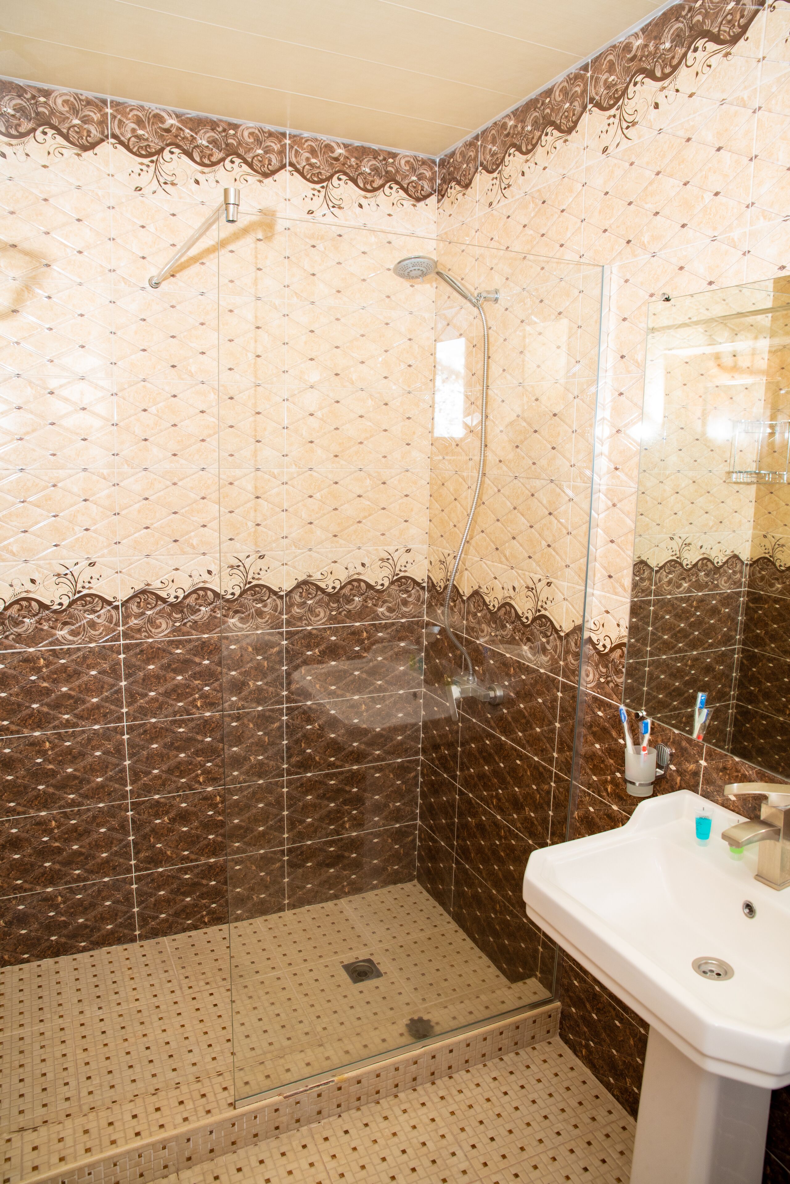 Ein Badezimmer mit Dusche, Waschbecken und Spiegel.