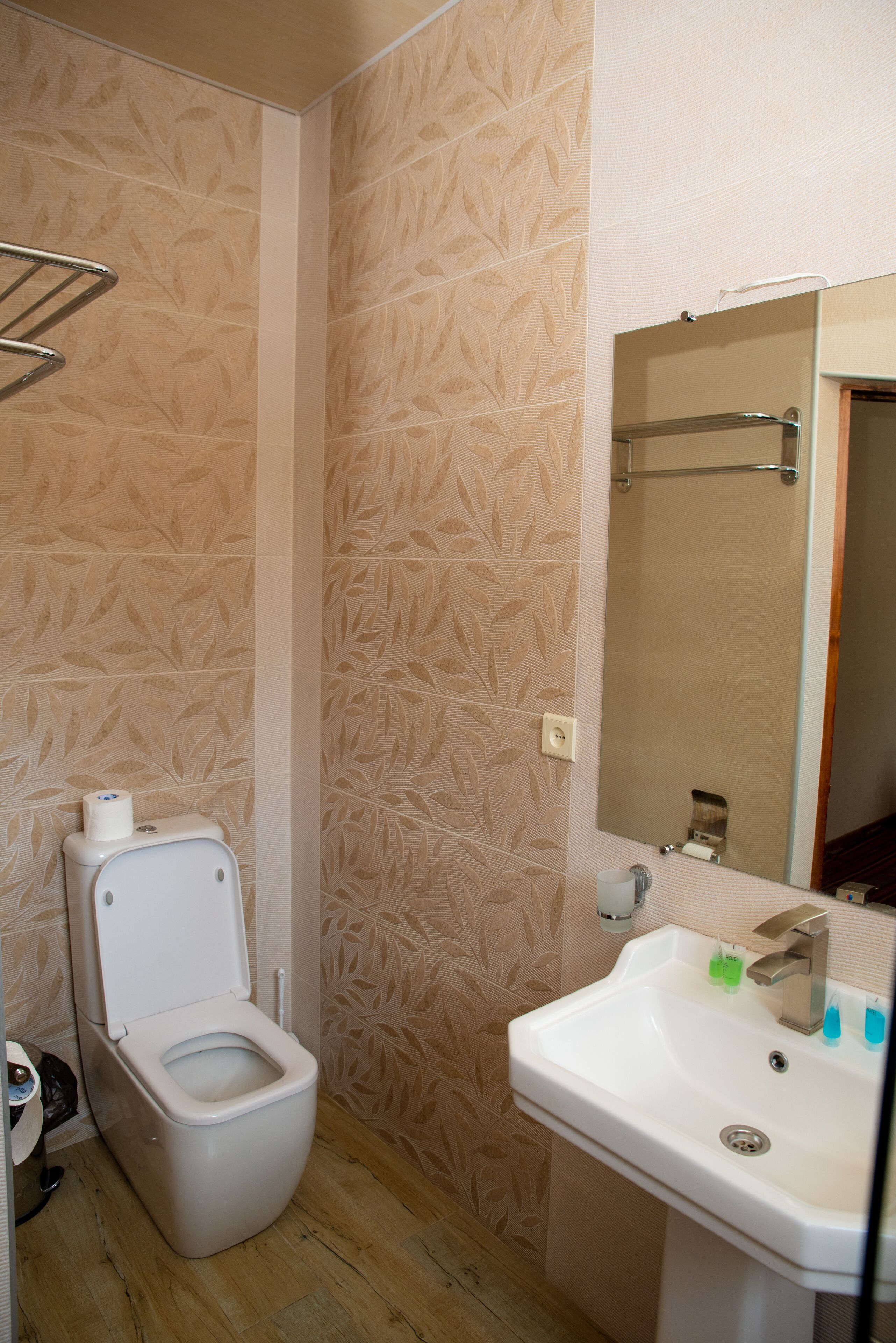 Un baño con inodoro, lavamanos y espejo.