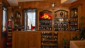 Una zona de bar con chimenea, estantes llenos de botellas y un refrigerador de Coca-Cola.