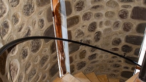 Un muro de piedra con una escalera en espiral.
