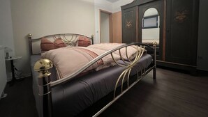 A bedroom with a bed, wardrobe, and bedside table. - Maison Euba am Zeisigwald (Euba)