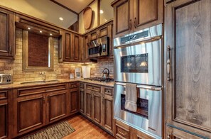 Enjoy cooking in this kitchen with a microwave, double oven, and stainless steel range hood.