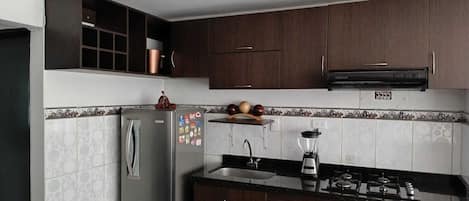 Comfort appartement | Privékeuken | Een koelkast, een blender, een bakplaat, kookgerei, borden en bestek