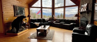 Ylellinen hirsimökki, josta on upeat näkymät ja kääri kannen ympärille