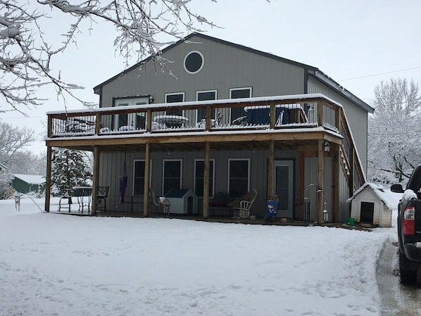 A two-story building with a balcony, a covered porch, and a small attached garage.