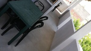 A small balcony with a table and chairs, a window, and a view of the outside. - Complejo Felesa Las Grutas (Las Grutas)