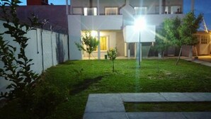 A modern two-story house with a well-maintained lawn and a small tree in the front yard. - Complejo Felesa Las Grutas (Las Grutas)