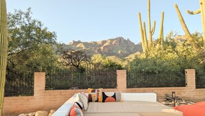 A patio with a view of desert cacti and mountains.