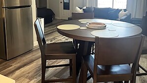 A modern kitchen with a built-in refrigerator, a dining table with chairs, and a living area with a sofa and a window. - Life's a beach and Tennis... (Bonita Springs)