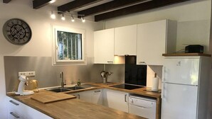 Una cocina moderna con armarios blancos, encimera de madera, lavavajillas empotrado y estufa negra.