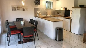Una cocina moderna con armarios blancos, un lavamanos de acero inoxidable y un lavavajillas integrado.