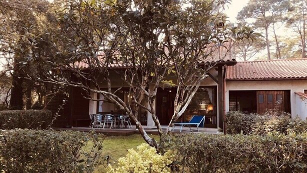 Una casa con patio, una mesa de comedor y sillas.
