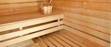 Una sauna de madera con bancos y una lámpara.