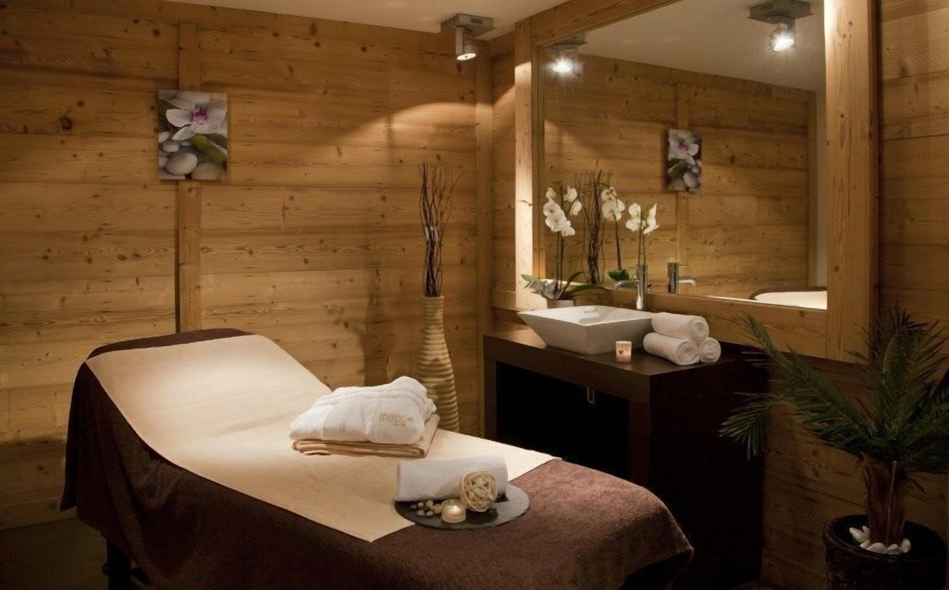 Una habitación de madera con una cama, un lavamanos y un espejo.