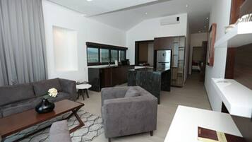 Habitación triple Premium | Área de sala de estar | Televisión de pantalla plana