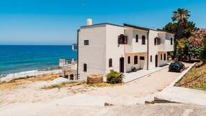 A two-story building with a flat roof, a balcony, and a car parked in front. - Apartment Pinta by Interhome (Marina di Caronia)