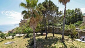 A coastal property with a stone staircase leading to a patio area, surrounded by palm trees and a view of the sea. - Apartment Pinta by Interhome (Marina di Caronia)