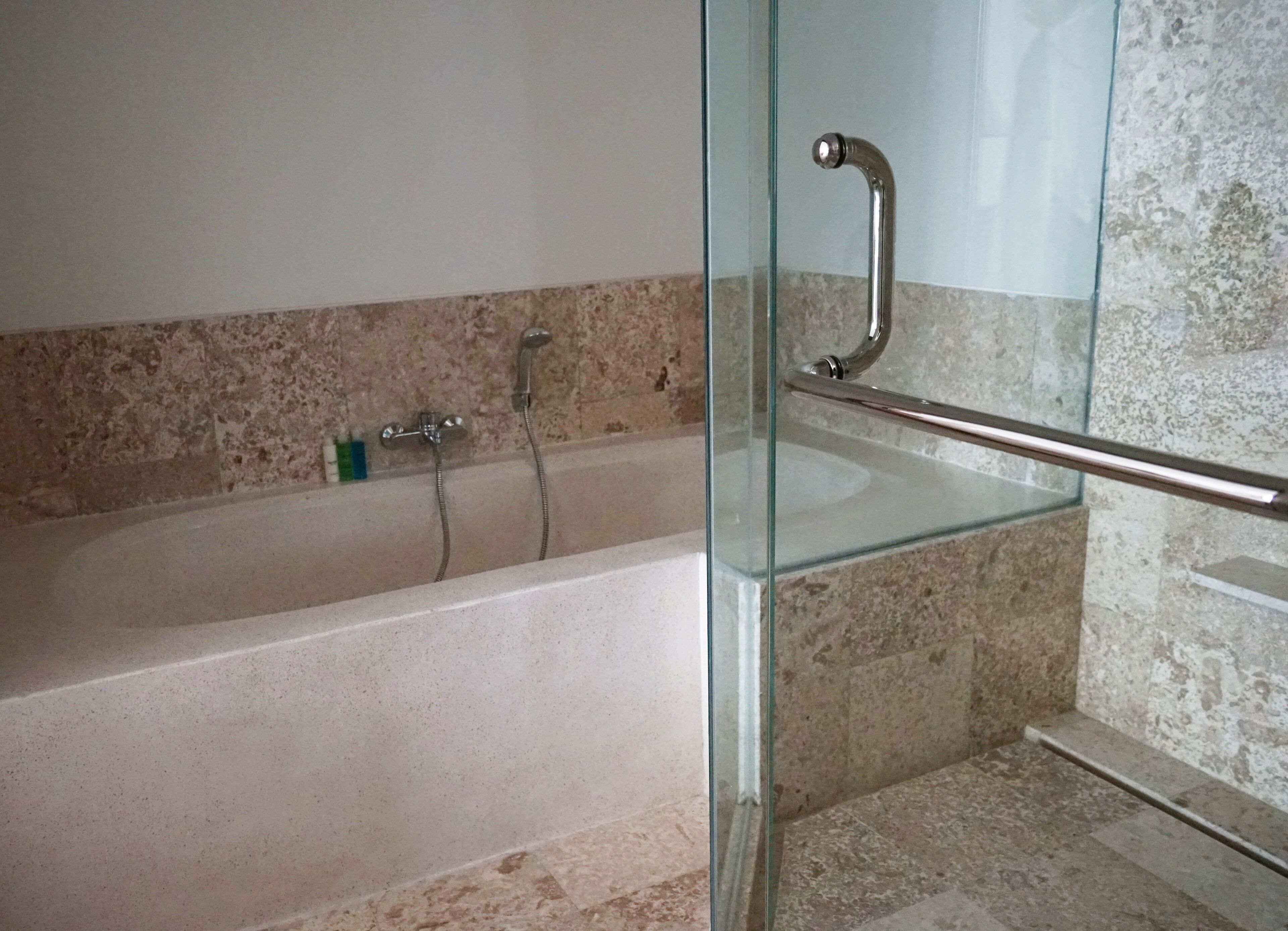 Une salle de bain moderne avec une douche à parois de verre, une baignoire et un lavabo en verre.