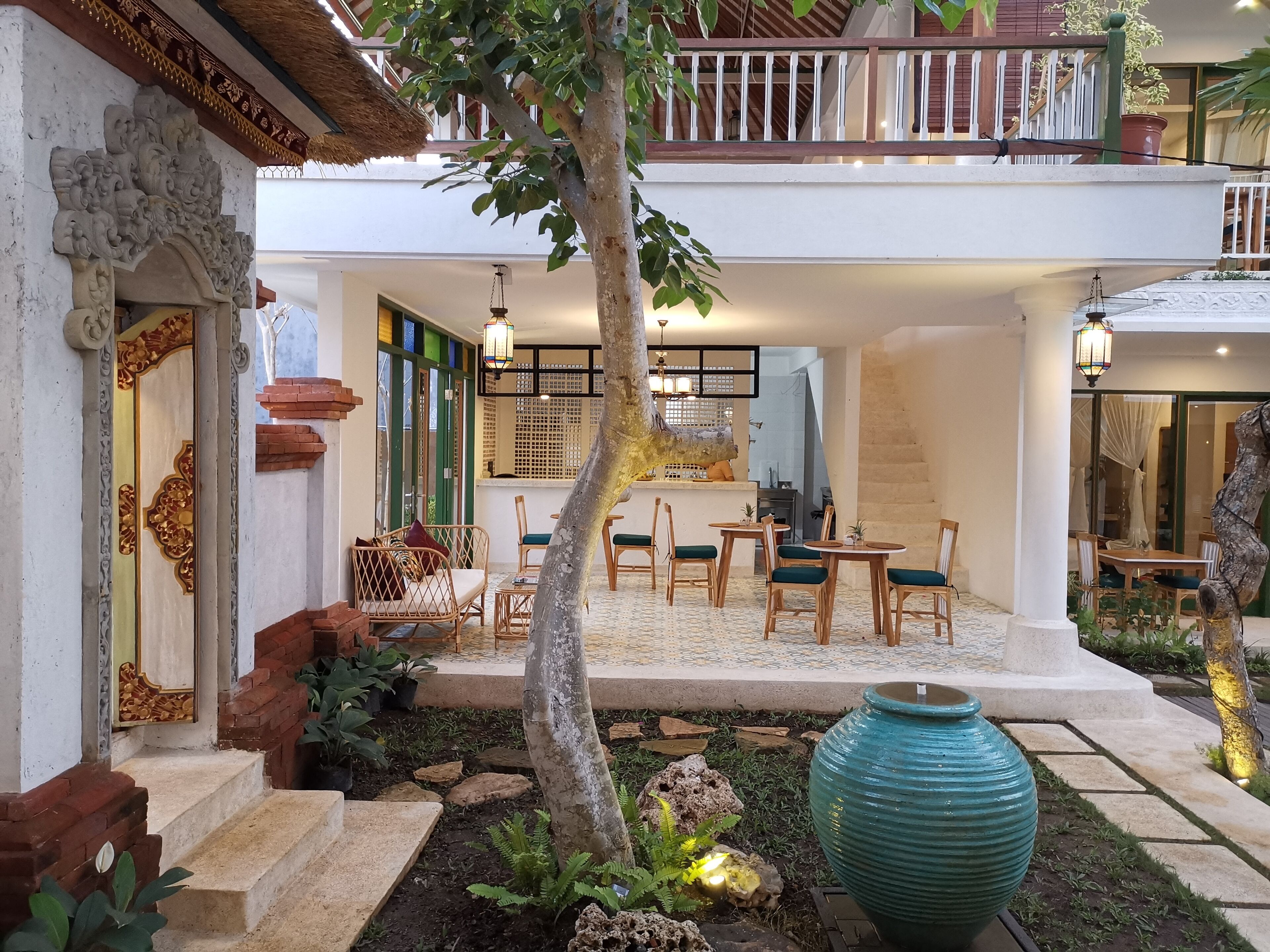 A courtyard with a dining area, outdoor seating, and a large decorative vase.