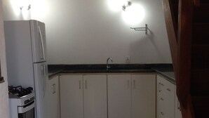 Eine Küche mit weißen Schränken, einer schwarzen Arbeitsplatte und einem eingebauten Backofen.