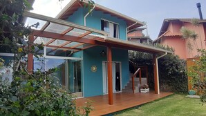 Ein modernes Haus mit Glastür, einer Holzdiele und einer Treppe, die zu einer zweiten Etage führt.