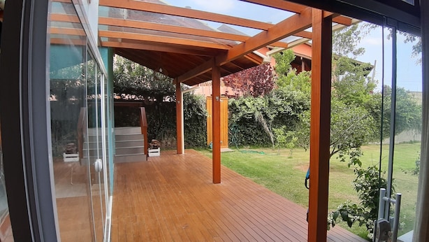 Eine moderne Außenterrasse mit Holzboden und einer Pergola.