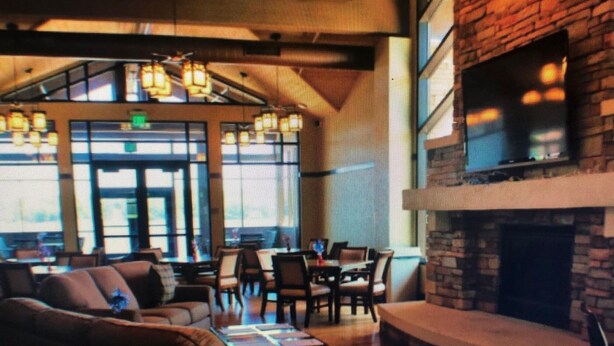 A cozy lounge area with a fireplace, comfortable seating, and a large window allowing natural light. - Come and enjoy the Breath taking  Vacation cabin at  Pocono , PA (pocono lake)
