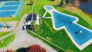 An aerial view of a residential area with a large swimming pool, tennis courts, and a solar panel array. - Come and enjoy the Breath taking  Vacation cabin at  Pocono , PA (pocono lake)