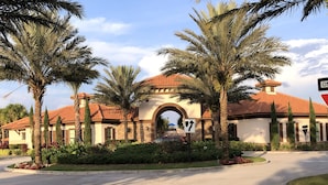 A building with a red-tiled roof, an arched entrance, and palm trees. - Solterra Resort - is a beautiful paradise located in Davenport, near to Orlando (Davenport)
