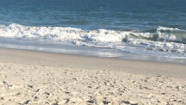 A sandy beach with waves approaching the shore. - Waipani E14-2BR -Beach Across The Street-Pool (North Myrtle Beach)