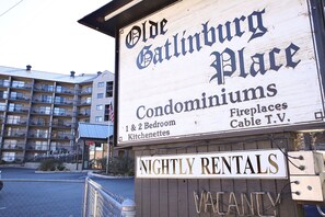 A sign for Olde Gatlinburg Place, indicating it offers 1 & 2 bedroom condominiums with fireplaces and cable TV.