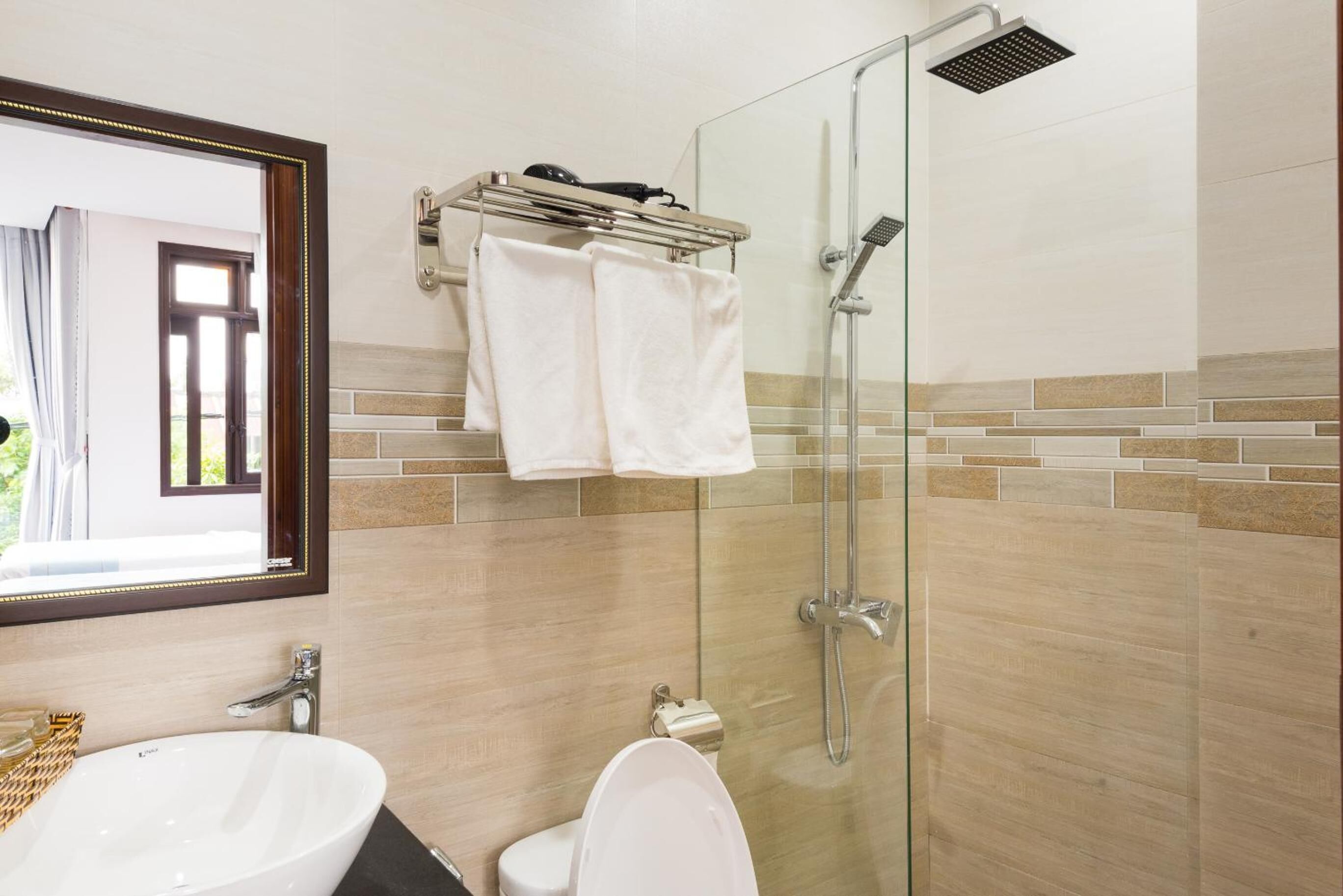 A bathroom with a glass-enclosed shower, a white sink, and a toilet.