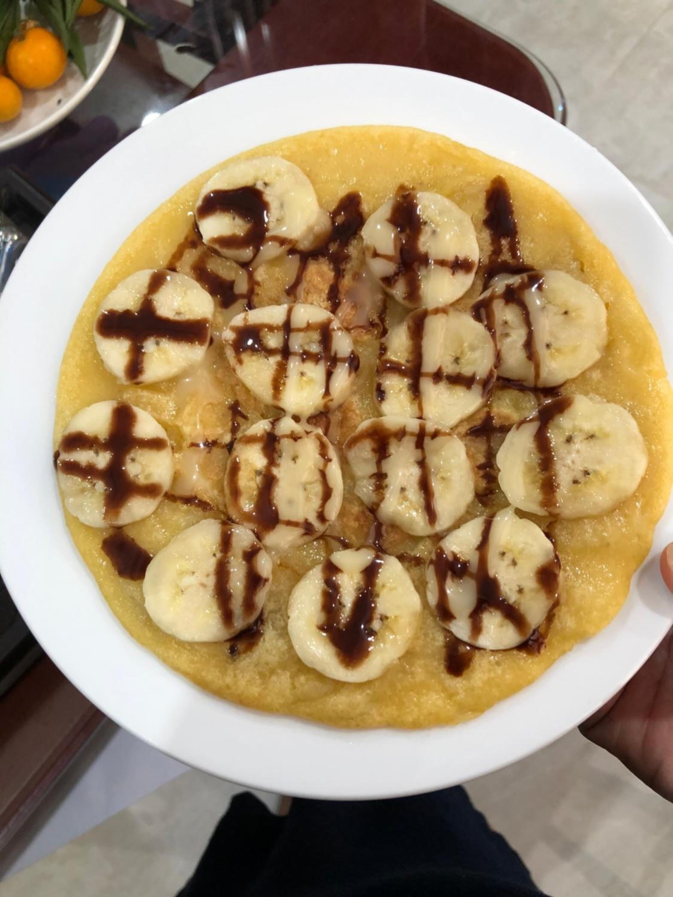 Ein Teller mit Bananenscheiben auf einer gelben Schale mit Schokoladenglasur.