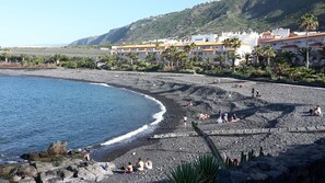 Ranta lähistöllä, aurinkotuoleja, rantapyyhkeitä